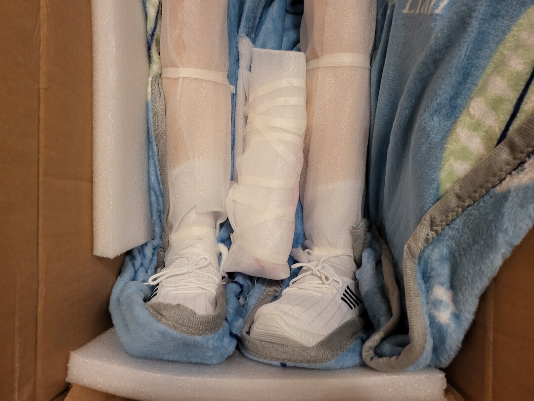 doll in box shoes on feet