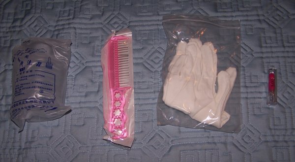 Goodie bag contents.<br />Irrigator, metal tooth comb, cotton gloves, and lipstick. A tube of nail glue and stain remover should also be in there, but mine must have fallen out because I found them in the box after taking out the doll.
